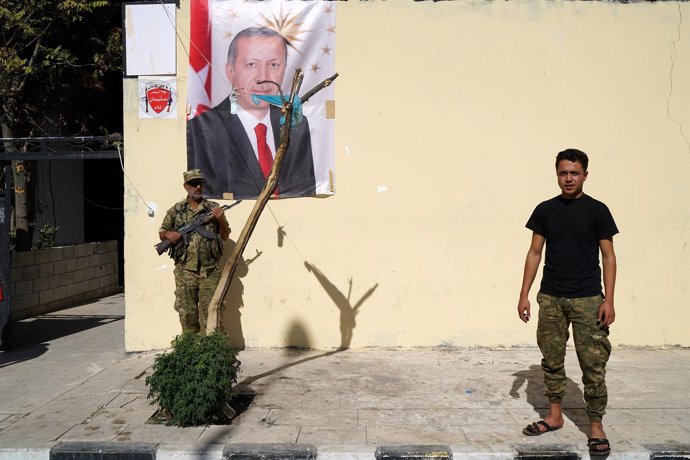 Miembro del ELS con un retrato de Erdogan en Jarablus