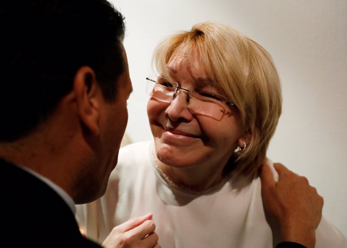 Venezuela's chief prosecutor Luisa Ortega Diaz (R) is greeted by a man after a n
