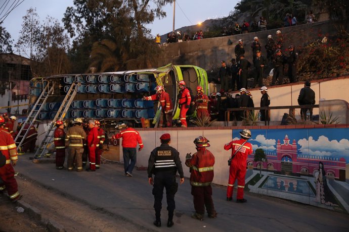 Police officers, firemen and rescue personnel inspect a double-decker tourist bu