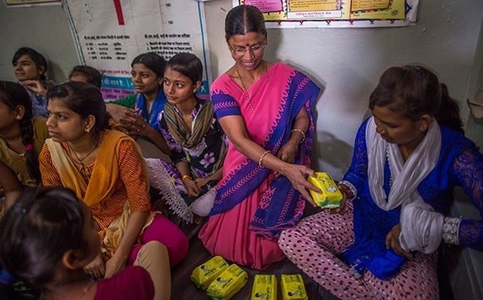 Una profesora reparte productos de higiene sanitaria entre las mujeres