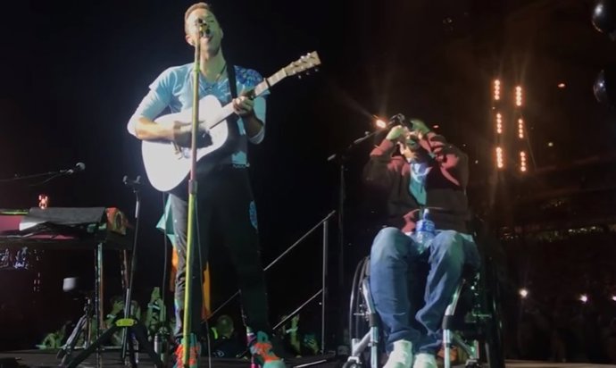 Fan de Coldplay en silla de ruedas sube al escenario a tocar con sus ídol