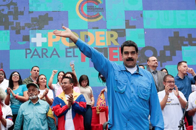 Venezuela's President Nicolas Maduro (C) waves as he arrives for an event with s