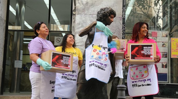 Empleadas del hogar colocan mandiles y escobas a estatuas del barrio de Malasaña