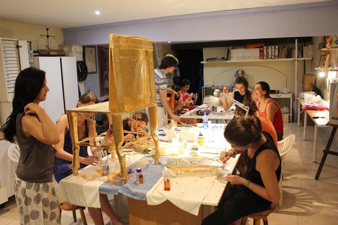 Toques de pan de oro finales al marco de madera del trono de Tutankamón