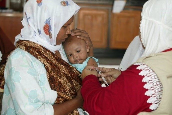 Mujer y niño recibe una vacuna