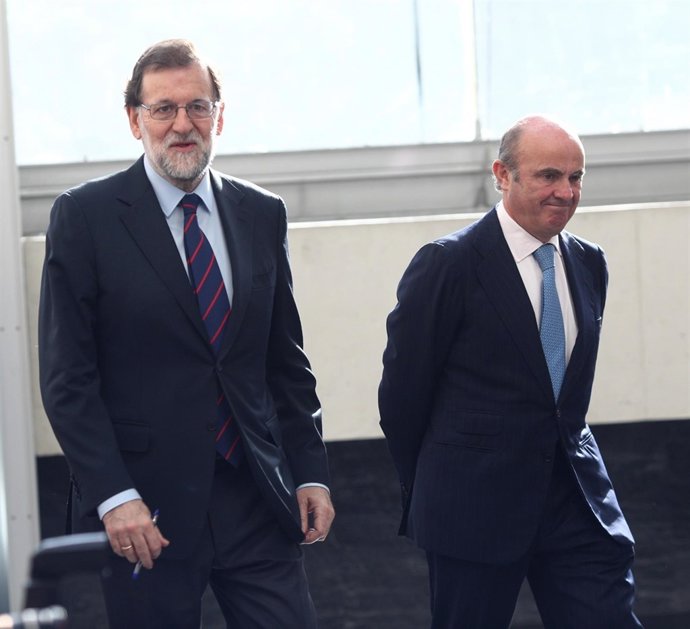 Luis de Guindos y Rajoy a su llegada a una jornada de la Cámara de Comercio