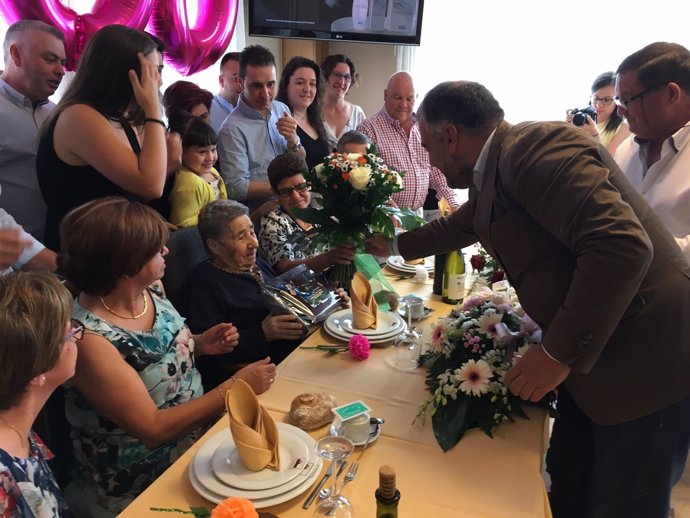 El alcalde hace entrega del ramo de flores a la centenaria.