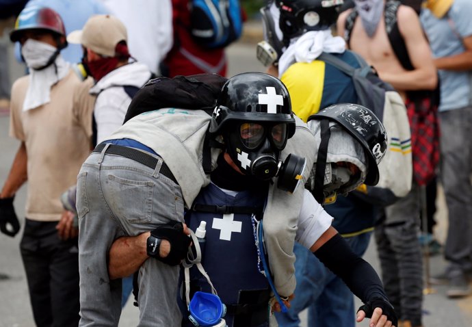 An injured demonstrator is helped during a rally against Venezuela's President N