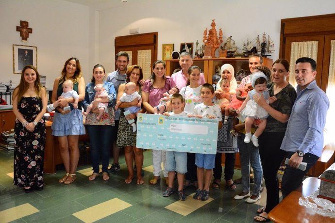 El alcalde de Palos, Carmelo Romero, entrega cheques bebé.