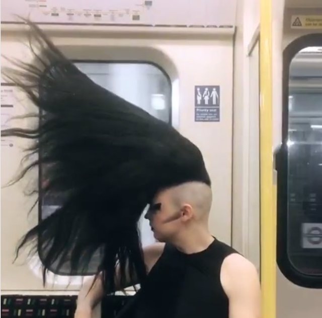 Joven con peinado especial viaja en metro