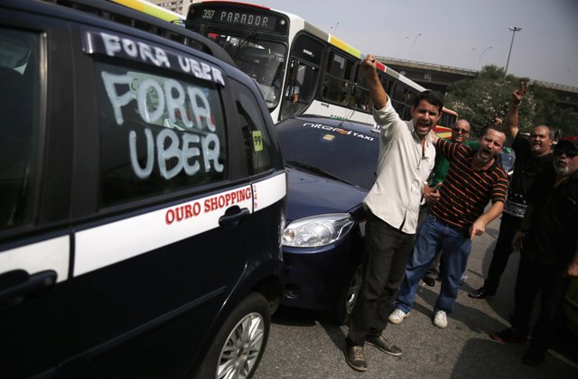 Taxi drivers shout slogans during a protest against the online car-sharing servi