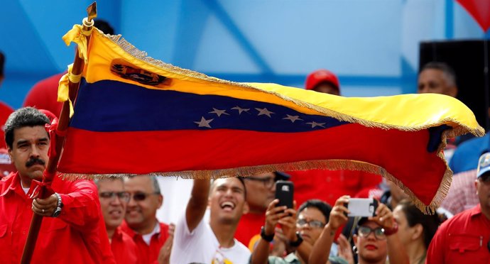 El presidente de Venezuela, Nicolás Maduro, ondea la bandera durante un mitin.