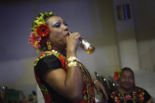 Pilar, a man dressed as traditional Zapotec also known as "Muxe", drinks beer du
