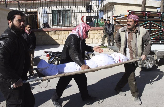 Hombres llevan en camilla a muertos por bombardeos en Siria, Alepo. 