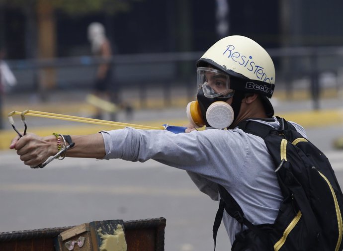 Manifestante de la oposición venezolana con un tirachinas