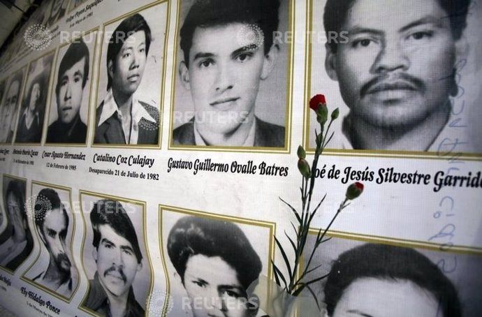 A red carnation is placed next to the photographs of people killed in Guatemala'