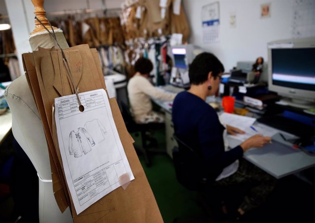 People work on computers at the sewing patterns area in a textile factory in Mad