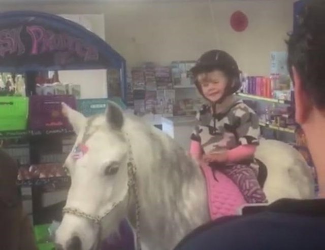 Una niña entra en poni en una tienda