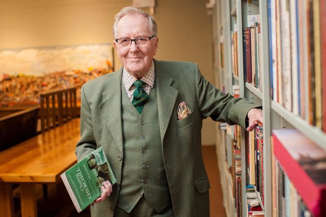 The actor Robert Hardy poses for a portrait alongside some of the books among hi