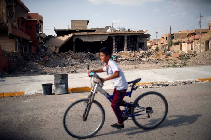 Un niño yazidí junto a una casa destruida en Sinjar