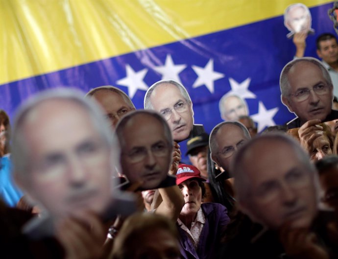 People hold portraits of opposition leader Antonio Ledezma during a news confere