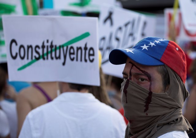 A demonstrator with a fake wound takes part in a protest held by Venezuelans in 