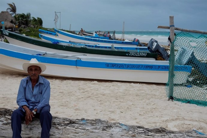 Un hombre junto a las barcas en la costa del estado de Quintana Roo.