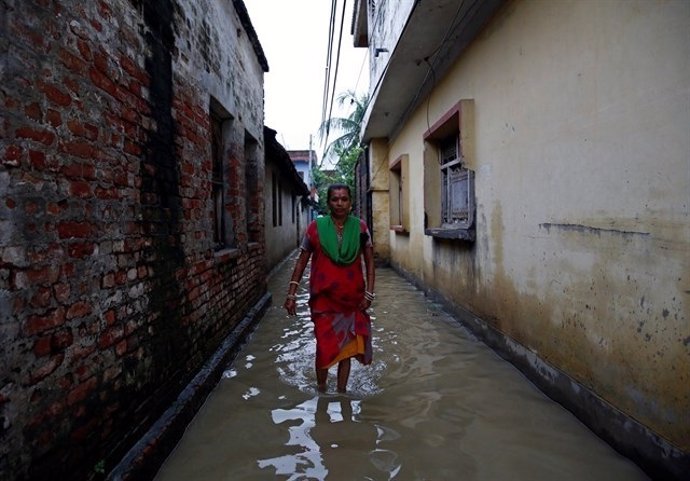Una mujer camina por una calle inudada en Nepal