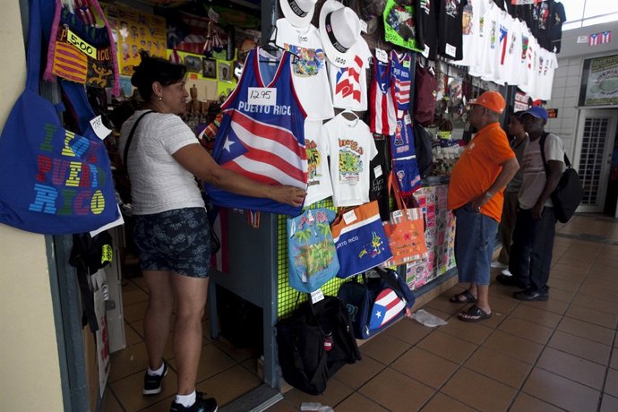 Ana Rodriguez, a tourist from California, looks at a shirt in a souvenir shop