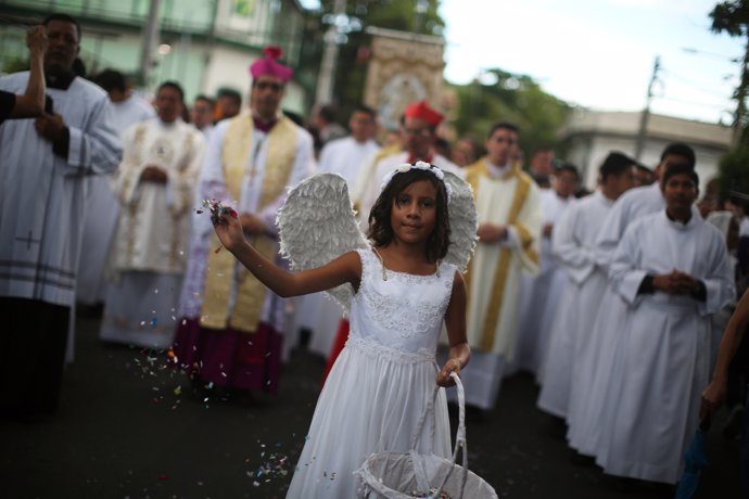 A girl throw confetti as she participates in a procession to commemorate the Fea