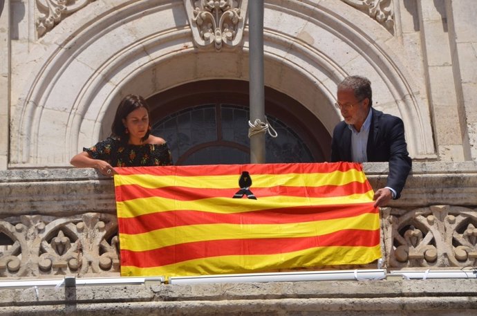 Los concejales María Sánchez y Manuel Saravia colocan la 'senyera' en el balcón 