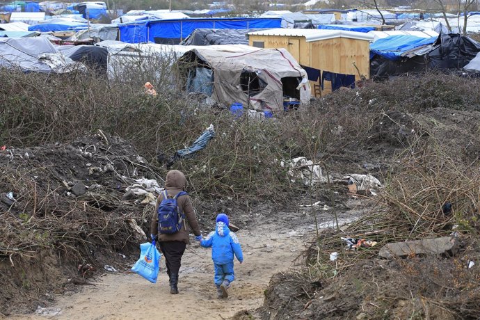 Un inmigrante y su hijo en un campamento de Calais, en una imagen de archivo