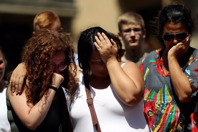 People react at an impromptu memorial a day after a van crashed into pedestrians