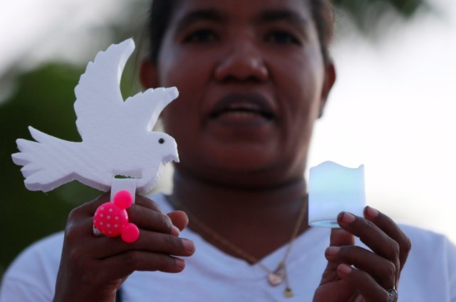 Una activista sostiene una paloma en señal de protesta contra la violencia.