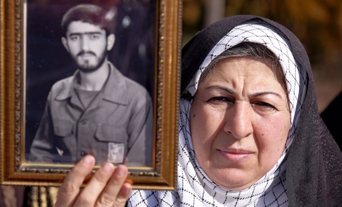 Mujer levanta foto de hijo muerto en guerra Irán-Irak