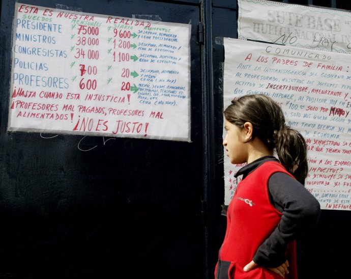 A student reads a poster at a Lima school comparing high salaries for
Top polit