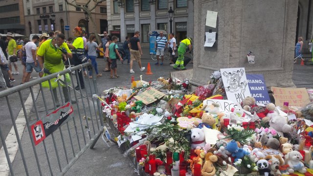 Altar por los atentados al inicio de La Rambla con operarios limpiando el suelo