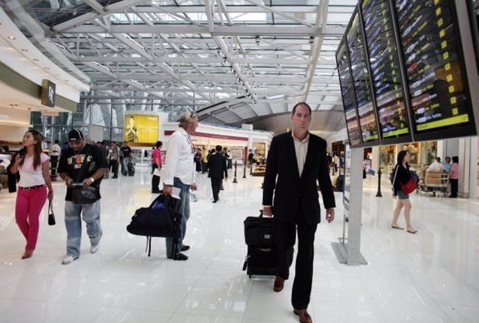 Pasajero en aeropuerto con maleta