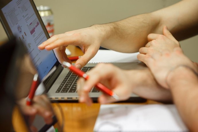 Alumnos consultan un ordenador