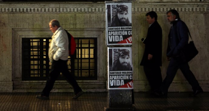 People walk past posters with a portrait of Santiago Maldonado, a protester who 