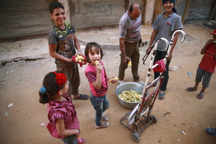 Children hold corncobs at Ain Tarma, eastern Damascus suburb of Ghouta, Syria Ju