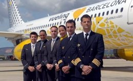 Un grupo personas de Vueling posa ante un avión de la compañía