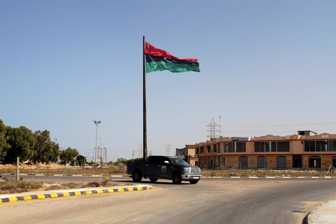Una bandera libia ondea a la entrada de Sirte