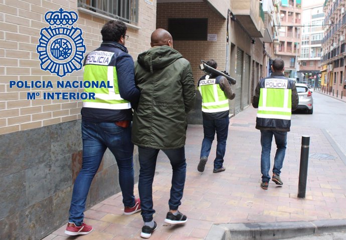 Agentes custodiando a uno de los detenidos