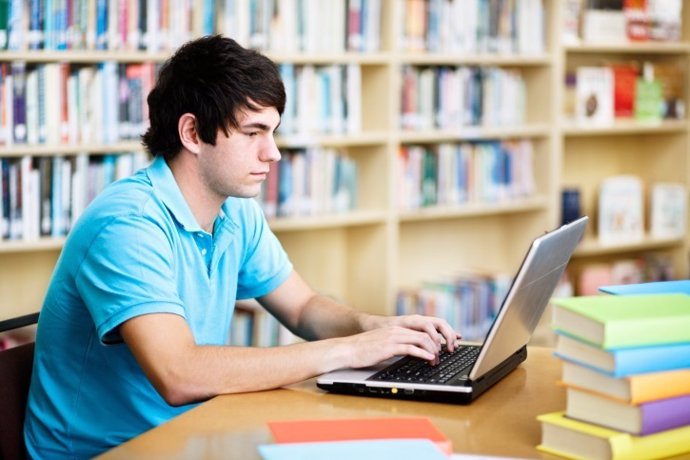 Estudiante, ordenador, libros, biblioteca, estudiando