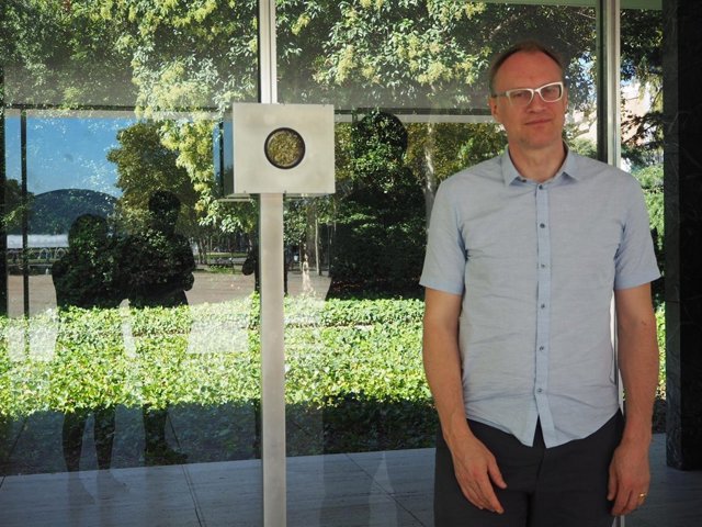 El fotógrafo Michael Wesley junto la cámara que ha instalado en el pabellón