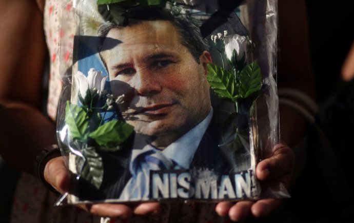 A woman holds up a photo of state prosecutor Alberto Nisman, lead investigator i