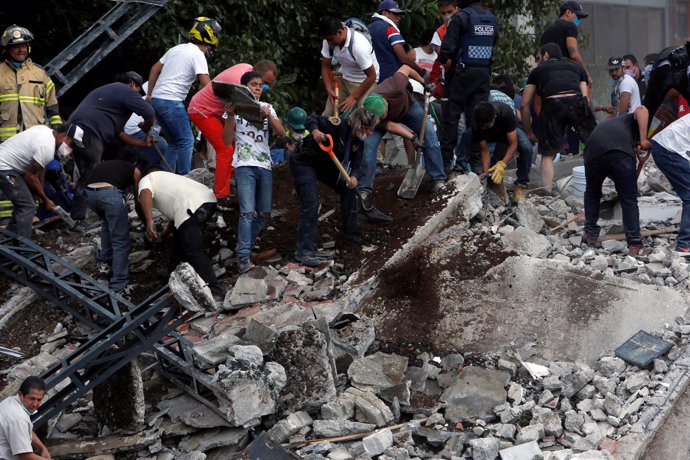 People remove debris of a collapsed building after an earthquake hit Mexico City