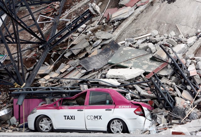 A damaged taxi is seen next to a collapsed building after an earthquake in Mexic