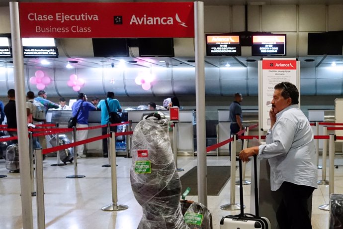 A man waits to do his check in the counter of Avianca airline, at the Simon Boli